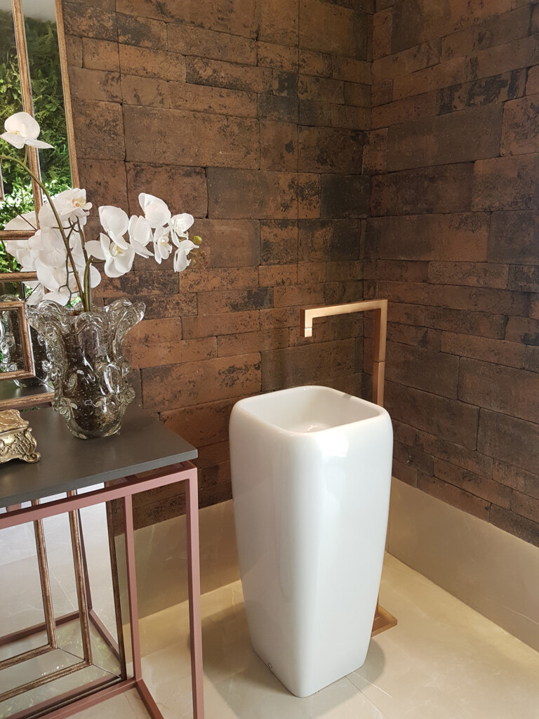 A decoração do lavabo foi trabalhada entre a delicadeza dos elementos minimalistas e a rusticidade do revestimento Ecobrick Grezzo.